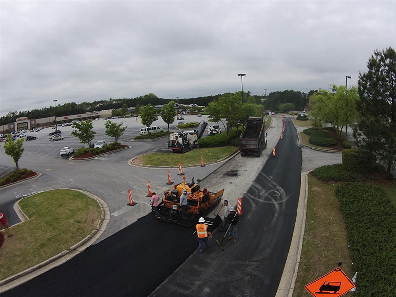 Crew performing asphalt maintenance services on commercial parking lot