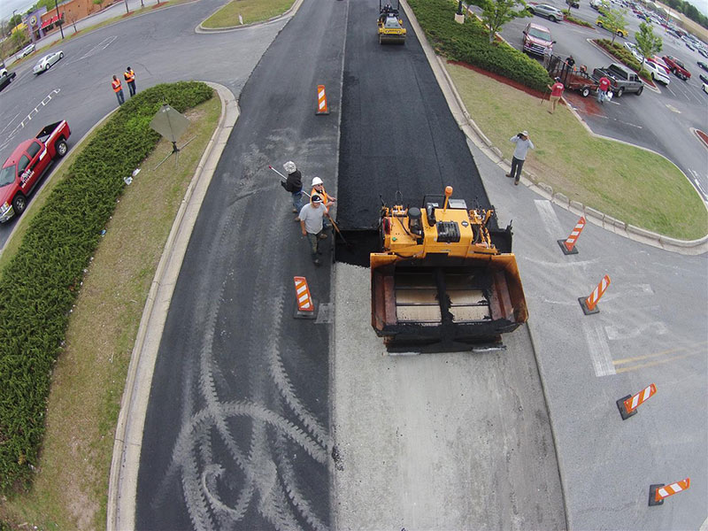 crew laying fresh asphalt in parking lot